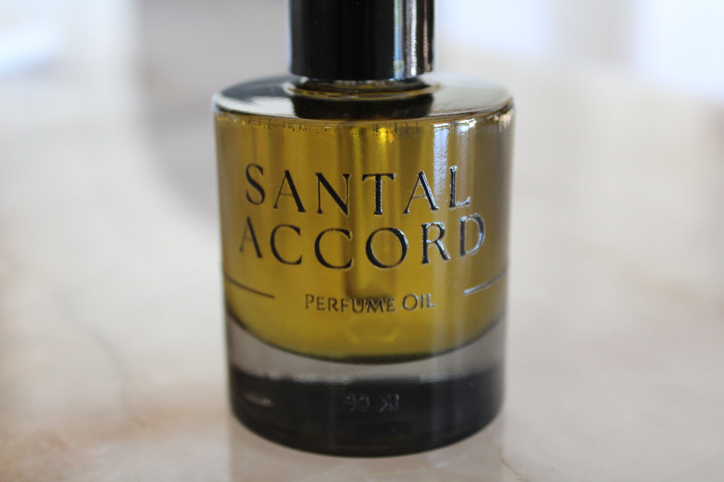 Bottle of Santal Accord perfume oil on a light background