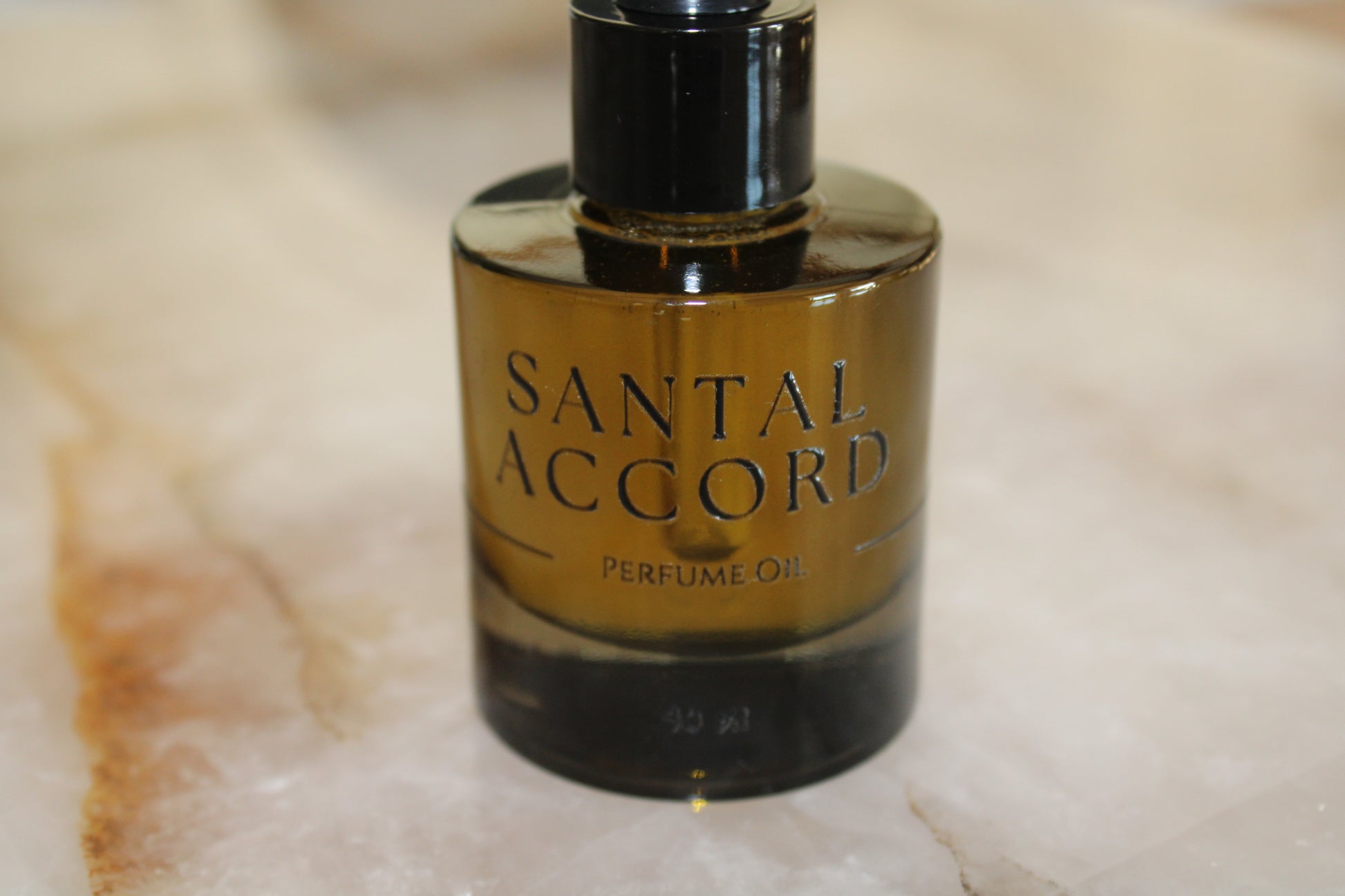 Santal Accord perfume oil bottle on a marble surface